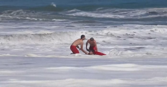 Dramatic video shows a 10-year-old boy rescued from pounding waves