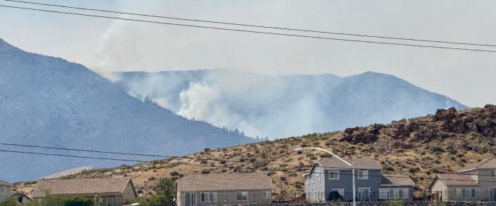 Firefighters are trying to stop a fast-moving Nevada wildfire from spreading to homes in Reno