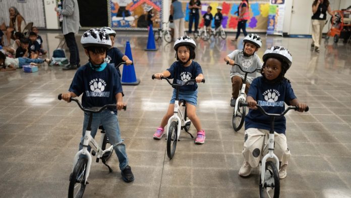 A childhood rite moves indoors as kindergartners learn to ride bikes in school gyms